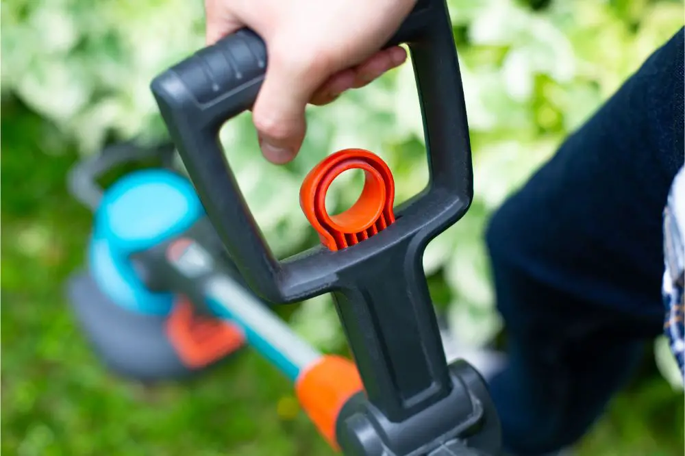 Cutting the lawn with cordless grass trimmer